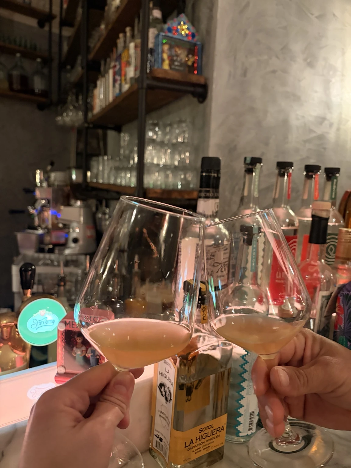 Zwei Gläser Tepache beim gemeinsamen Anstoßen an einer Bar